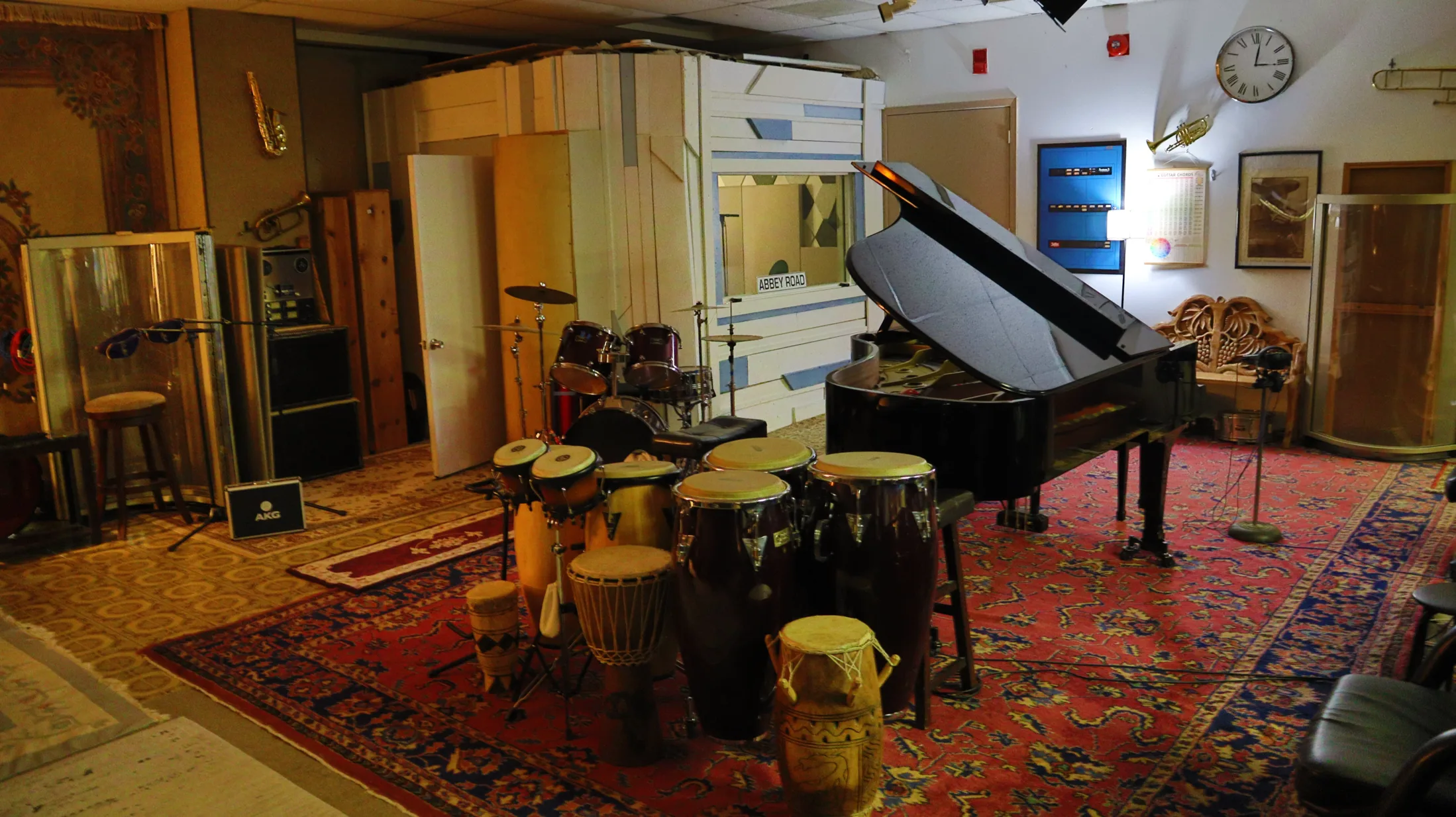 Live room with piano, percussion, and recording setup